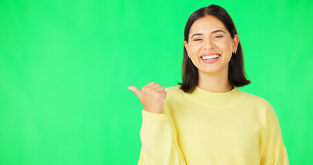 Portrait, pointing and branding with a woman on green screen space in studio for marketing or product placement. Hand gesture, advertising and options with an attractive young female on chromakey