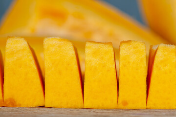 Sweet ripe orange pumpkin is sliced on the table