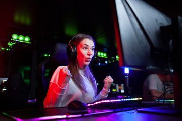 surprised girl in headphones plays a computer game and looks at the monitor with surprise, emotional gamer © Богдан Маліцький