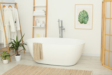 Obraz na płótnie Canvas Stylish bathroom interior with beautiful tub and houseplants