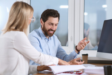 Fototapeta premium Happy businesspeople working with documents at table in office