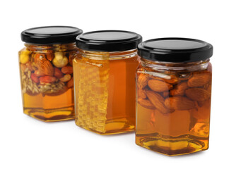 Jars with different nuts and honey on white background