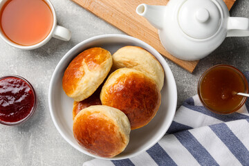Tasty scones prepared on soda water, jam and tea on grey marble table, flat lay