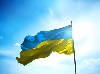 Ukraine flag waving on the blue sky with sunlight
