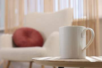 White mug on wooden table indoors, space for text