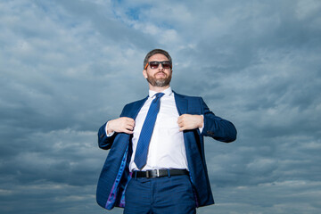 photo of businesslike businessman in suit. businessman in suit on sky background.