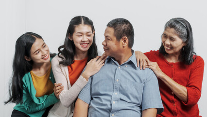 Happy anniversary day family of Elderly father and mother with old sister and young sister real people sitting together on sofa, Do activities together with love happily in the summer.