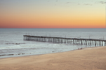 Fototapeta na wymiar Wooden pier going out into the ocean, on Virginia Beach. 