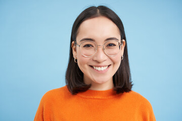 Portrait of smiling beautiful woman in glasses, testing her eyesight, wearing new spectacles,...