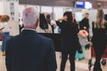 Meeting at the airport, person holding a placard card sign with welcome title text, greeting passenger on arrival, holding a name plate to receive a traveler, arrival area at international terminal
