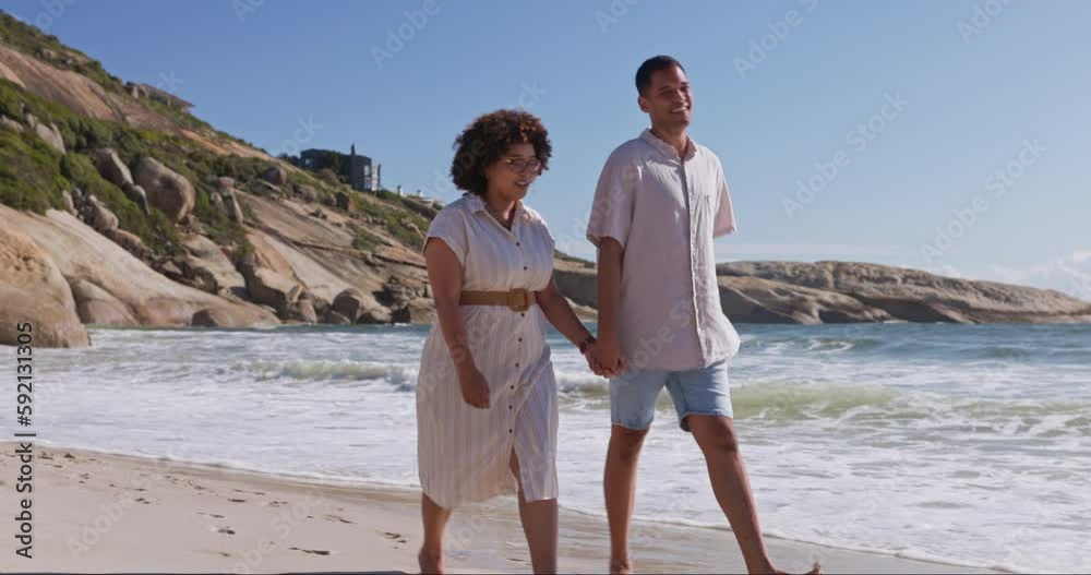 Wall mural Walking, love and holding hands with couple at beach for travel, relax and summer vacation. Happy, relationship and romance with man and woman on date for bonding, affectionate and commitment