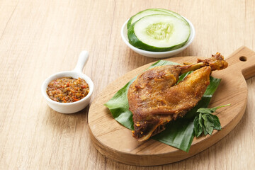 Bebek Goreng, served with chili sauce (sambal) and cucumber. Indonesian food
