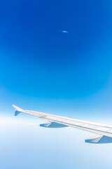 View from the airplane window at a beautiful cloudy sky and the airplane wing