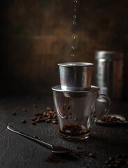 Preparation of Vietnamese coffe with aluminum cofe filer on dark background