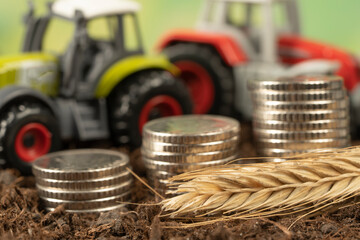 A small tractor in the garden with black soil. The concept of harvesting and making money on...