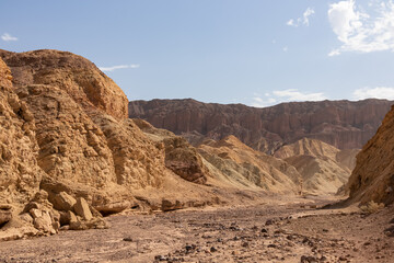 Fototapeta premium Golden Canyon trailhead with scenic view of colorful geology of multi hued Amargosa Chaos rock formations, Death Valley National Park, Furnace Creek, California, USA. Barren Artist Palette landscape