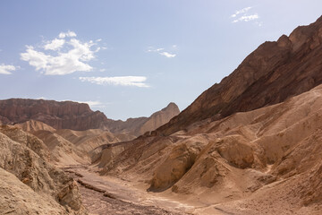Golden Canyon trailhead with scenic view of colorful geology of multi hued Amargosa Chaos rock formations, Death Valley National Park, Furnace Creek, California, USA. Barren Artist Palette landscape
