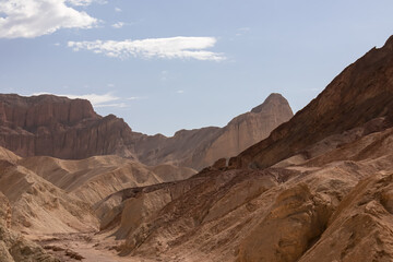 Fototapeta premium Golden Canyon trailhead with scenic view of colorful geology of multi hued Amargosa Chaos rock formations, Death Valley National Park, Furnace Creek, California, USA. Barren Artist Palette landscape