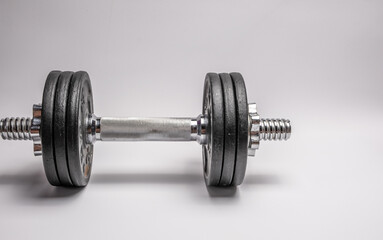 Fototapeta na wymiar Iron dumbbell with pancakes on a white background. Sports with weights.