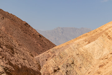 Golden Canyon trailhead with scenic view of colorful geology of multi hued Amargosa Chaos rock formations, Death Valley National Park, Furnace Creek, California, USA. Barren Artist Palette landscape