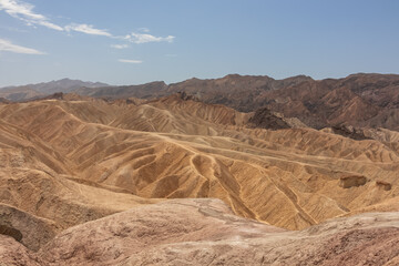 Scenic view of Badlands of Zabriskie Point, Furnace creek, Death Valley National Park, California, USA. Erosional landscape of multi hued Amargosa Chaos rock formations, Panamint Range in the back
