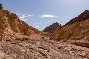 Fototapeta premium Golden Canyon trailhead with scenic view of colorful geology of multi hued Amargosa Chaos rock formations, Death Valley National Park, Furnace Creek, California, USA. Barren Artist Palette landscape