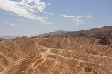 Scenic view of Badlands of Zabriskie Point, Furnace creek, Death Valley National Park, California, USA. Erosional landscape of multi hued Amargosa Chaos rock formations, Panamint Range in the back