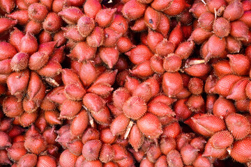 Close-up red salacca wallichiana fruit group for sale in a market. Top view.