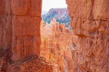 Scenic view through window of narrow massive steep hoodoo sandstone rock formation towers on natural amphitheatre in Bryce Canyon National Park, Utah, USA. Queens Garden loop hiking trail in summer
