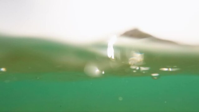 Waves on the ocean. The camera goes under water. Video recorded in slow motion.