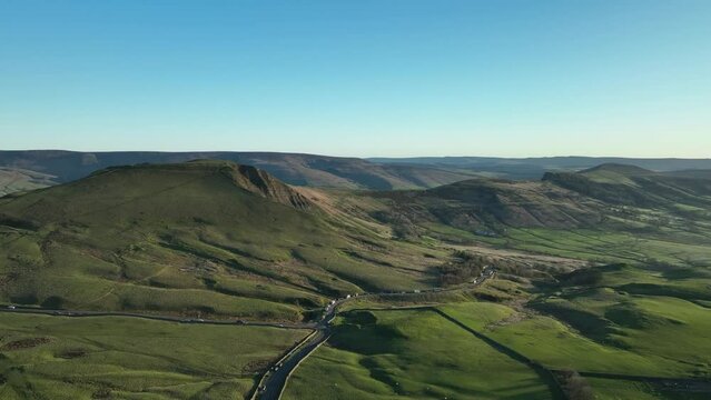 Wide aerial establishing shot of Mam Tor with views across the great ridge at Sunrise in the Peak District, UK