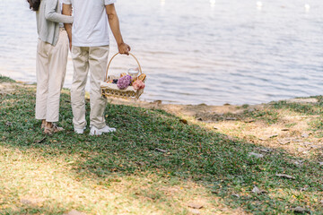 Couple walking in garden with picnic basket. in love couple is enjoying picnic time in park outdoors