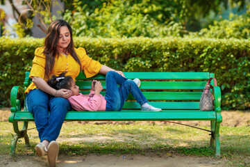 Indian little girl using smartphone with her mother at park