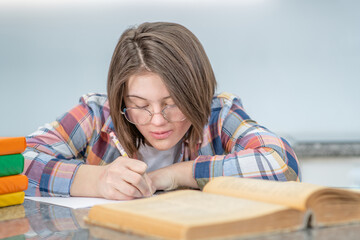 Young girl with Downs syndrome doing homework at home