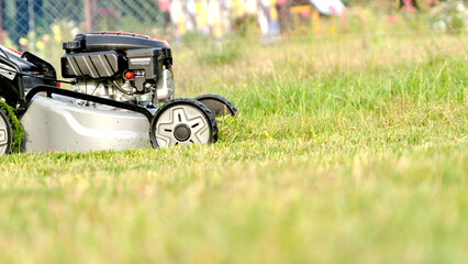 Lawn mover on green grass in modern garden. Machine for cutting lawns.