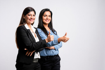Two young indian business woman or employee showing thumps up on white background.