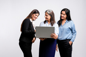 Fototapeta na wymiar senior female executive showing detail in laptop to his two young colleague.