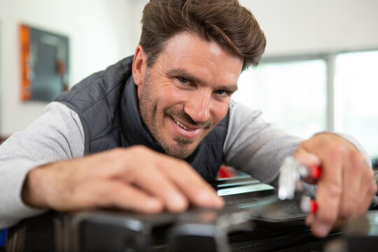 close-up of a smiling mechanic inside his auto repair shop