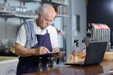 male barista using tablet on counter bar