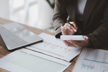 Businessman using a calculator to calculate numbers on a company's financial documents, she is analyzing historical financial data to plan how to grow the company. Financial concept.