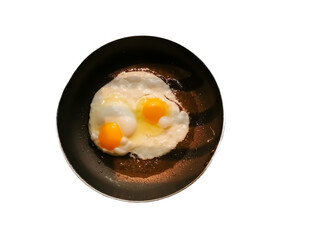 Top view of two fried eggs on black plate isolated on white background.
