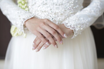 the bride's hands are decorated with white henna which is very beautiful