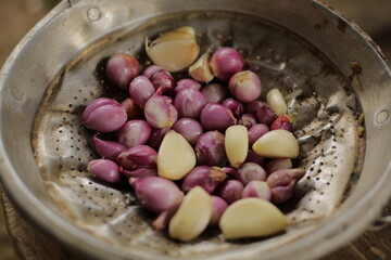garlic and shallots that have been peeled and placed in a container