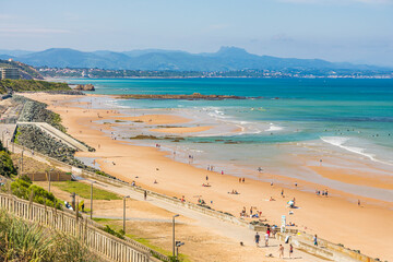 Cote des Basques beach and Pyrenees mountain in the background in Biarritz, France on a summer day - obrazy, fototapety, plakaty