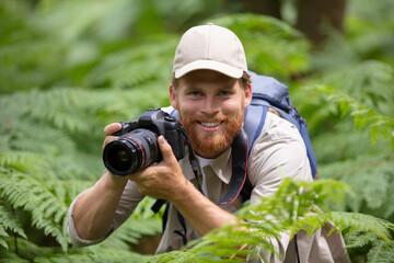 Fototapeta premium photographer in nature taking pictures of plants