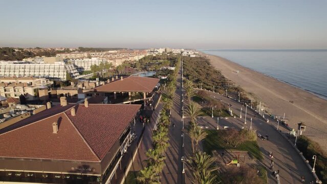 Aerial pullback along Islantilla promenade by the sand beach and resorts