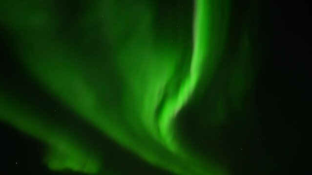 Close up of floating green illuminating protons of Northern Lights against dark sky