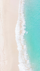 Aerial top view on nature landscape view of beautiful tropical clean sandy beach and soft blue ocean. Aerial top-down drone view.
