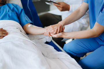 Obraz premium Female doctor holding male patient hand on the bed with receiving saline solution in hospital .