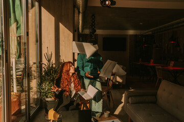 Naklejka premium Angry ginger businesswoman arguing with her colleague. She is throwing paperwork all over the workplace